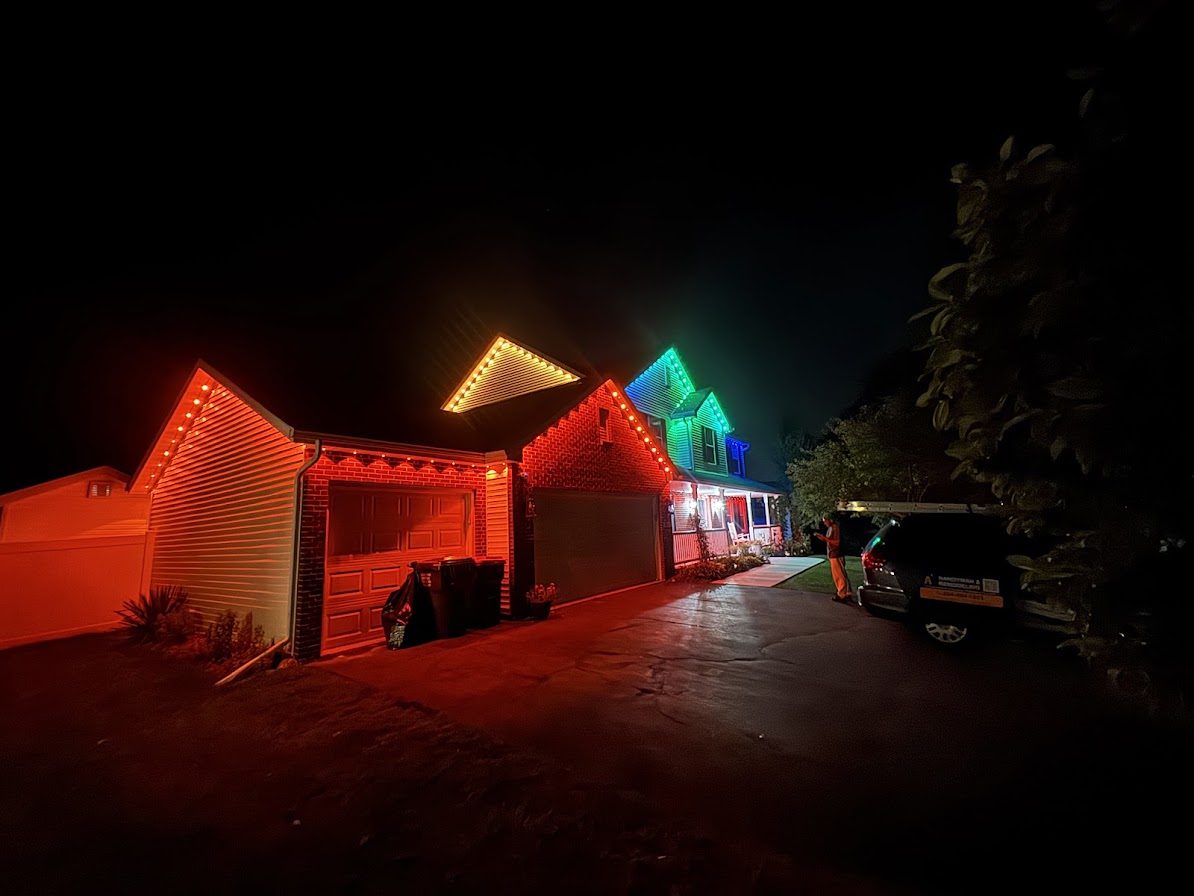 House at night with multicolor permanent roofline lighting