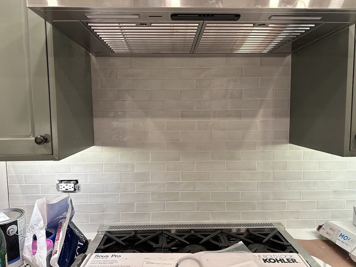 White subway tile backsplash behind a kitchen range