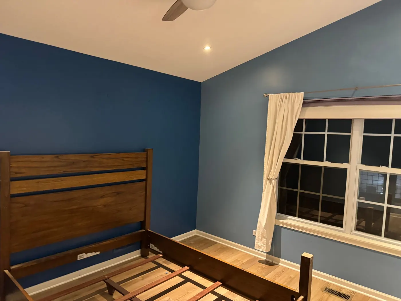Finished bedroom with blue painted walls and a white ceiling